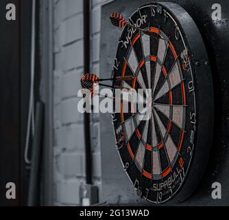 Grayscale shot of a dartboard hanging on the wall Stock Photo