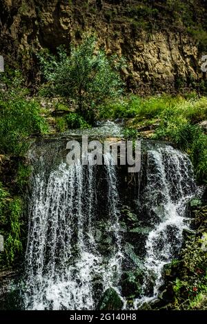 Summer background with waterfall stream among rocks Stock Photo
