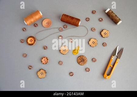accessories for sewing and needlework: buttons, scissors, needle with thread, set of reel of thread, top view Stock Photo