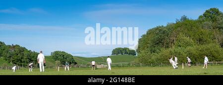 Wensleydale, UK. 04th June, 2021. 4 June 2021 - Hawes, North Yorkshire - Village cricket in what has to be one of the most scenic little grounds as Hawes bat on their home ground at Haylands on the banks of the River Ure. Credit: Wayne HUTCHINSON/Alamy Live News Stock Photo