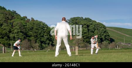 Wensleydale, UK. 04th June, 2021. 4 June 2021 - Hawes, North Yorkshire - Village cricket in what has to be one of the most scenic little grounds as Hawes bat on their home ground at Haylands on the banks of the River Ure. Credit: Wayne HUTCHINSON/Alamy Live News Stock Photo