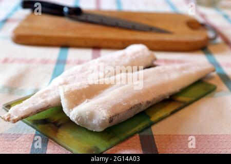 Whole raw fish between slices of bread on a blue colored table. Eating raw  fish concept with a frozen dorado fish in a sandwich Stock Photo - Alamy