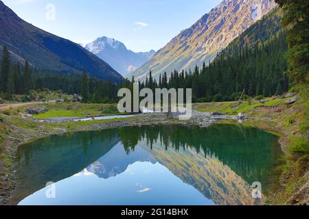 Reflection of the mountains in Barskaun Gorge in Kyrgyzstan Stock Photo