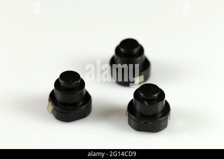 Miniature black button Latching. The button is used in lanterns. Electronic components. Stock Photo