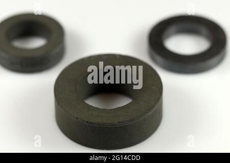 Black ferrite rings for making inductors. Rings of various sizes. Selective focus. Electronic components. Stock Photo