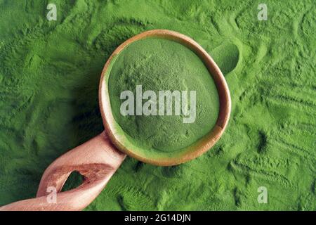 Green chlorella algae powder on a wooden spoon. Healthy nutritional supplement. Stock Photo