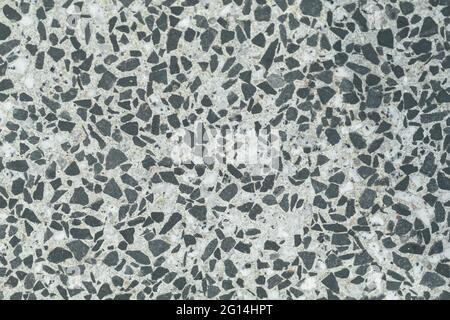 Texture of granite chips in concrete close-up. Colored granite floor, textured background. Concrete floor, strewn with scaly stone and smooth. Stock Photo
