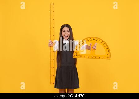 happy teen girl hold protractor ruler. back to school. algebra and geometry. kid study math. Stock Photo