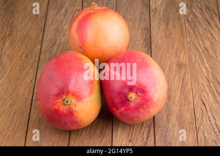 Mangifera indica - Delicious tommy mango on wooden table Stock Photo