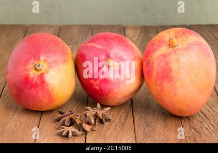 Delicious tommy mango on wooden table - Mangifera indica Stock Photo