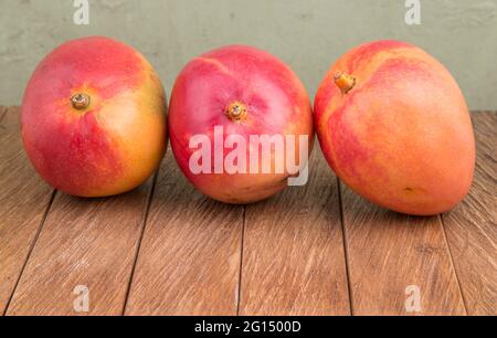 Mangifera indica - Delicious tommy mango on wooden table Stock Photo