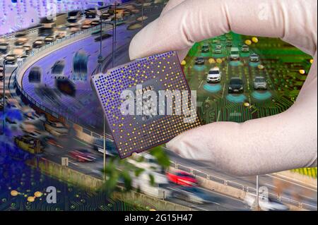 The computer circuit board and fast-moving cars. A hand holding a CPU chipset. Stock Photo