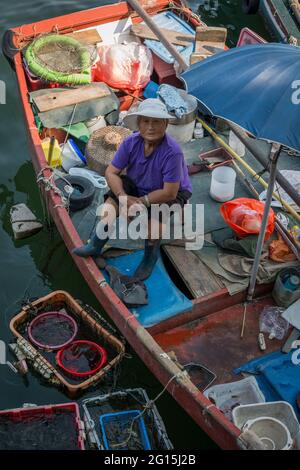 A local fisherwoman sells her catch directly from her boat at the waterfront, Sai Kung, New Territories, Hong Kong Stock Photo