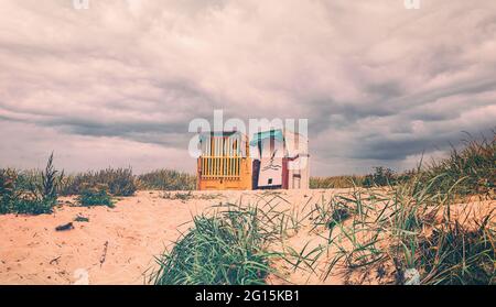Two beach chairs on the beautiful sandy beach in autumn at the North Sea. Beach with baskets in Cuxhaven on the German North Sea coast. Stock Photo