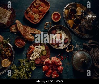 Top view of traditional Turkish breakfast including fried eggs and sausages served on wooden table with dried fruits and tea Stock Photo