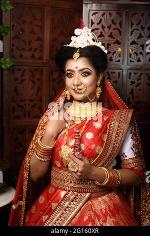 Portrait of very beautiful Indian bride holding traditional wooden sindur or sindoor box in hand, Wedding symbol sindoor box. Wedding Lifestyle and Fa Stock Photo