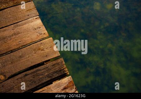 Warm background summer vacation. Wooden planks over the water of lake Stock Photo