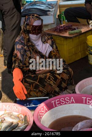 Bandari woman wearing a traditional burqa (mask) on the fish market of Bandar Abbas, Hormozgān Province, Iran Stock Photo