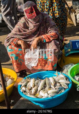 Bandari woman wearing a traditional burqa (mask) on the fish market of Bandar Abbas, Hormozgān Province, Iran Stock Photo