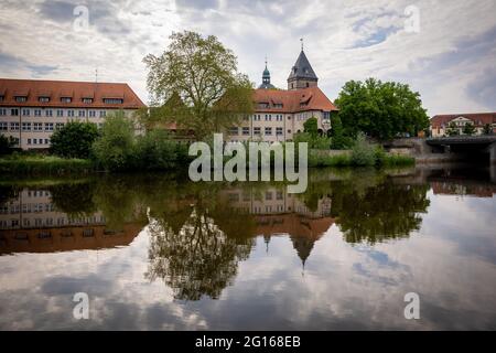 Hameln, Germany. 05th June, 2021. The towers of the church Münster St. Bonifatius are reflected in the river Weser in cloudy weather. Credit: Moritz Frankenberg/dpa/Alamy Live News Stock Photo