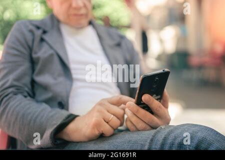 A man uses a smartphone and sends a message Stock Photo