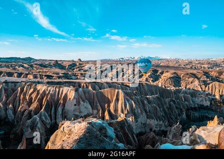 Göreme, Cappadocia, Turkey - March 19, 2021 - beautiful aerial view of hot air balloons flying over amazing landscapes with fairy chimneys Stock Photo
