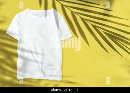 T-shirt mockup Floral summer template. Palm leaves shadow on yellow background Stock Photo