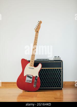 Red electric guitar on white wall Stock Photo