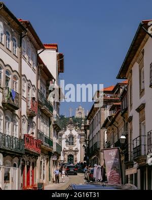 Small Road with Traditional Houses with Balconies and 'Capela das Malheiras' Church - Viana do Castelo, Portugal Stock Photo