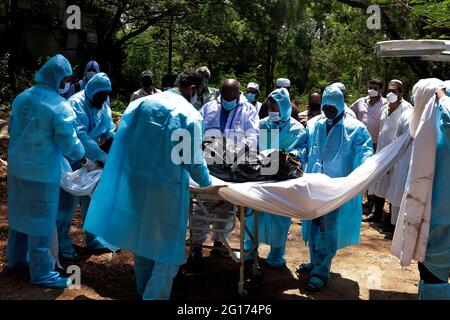 Chennai, India. 05th June, 2021. Volunteers along with graveyard workers wearing protective gear prepare to bury the body of a man who died of Covid-19 corona virus in a burial pit in Chennai. (Photo by Sri Loganathan Velmurugan/Pacific Press) Credit: Pacific Press Media Production Corp./Alamy Live News Stock Photo