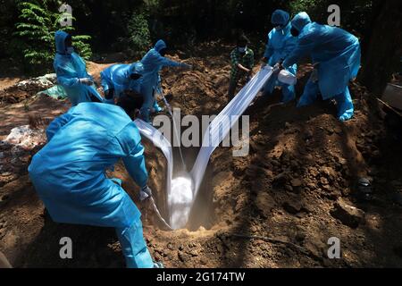 Chennai, India. 05th June, 2021. Volunteers along with graveyard workers wearing protective gear lower a body of a man who died of Covid-19 corona virus in a burial pit in Chennai. (Photo by Sri Loganathan Velmurugan/Pacific Press) Credit: Pacific Press Media Production Corp./Alamy Live News Stock Photo