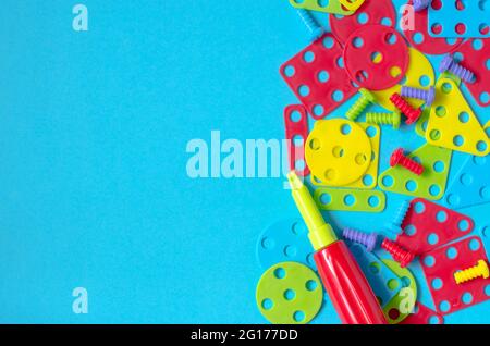 Elements of children's multicolored constructor on a blue background with a place for text Stock Photo