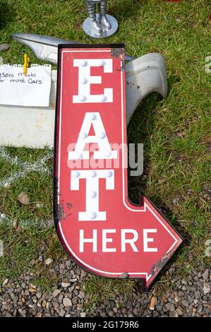 Restaurant sign reading “ Eat Here” in white on a red background for sale at a classic car show in Norfolk Stock Photo