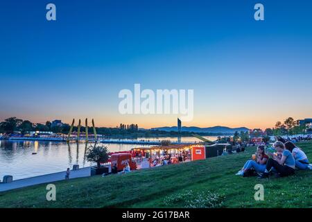 Wien, Vienna: sunset at Copa Beach, river Neue Donau (New Danube), people on meadow, view to Wienerwald in 22. Donaustadt, Wien, Austria Stock Photo