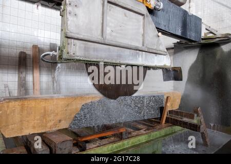 Machine for cutting granite stones. Cutting granite in a stonemason's workshop. Stock Photo