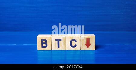 BTC wooden blocks and down arrow. Cryptocurrency concept. Decentralized digital currency. Blockchain. The fall of bitcoin. Technologies. Stock Photo
