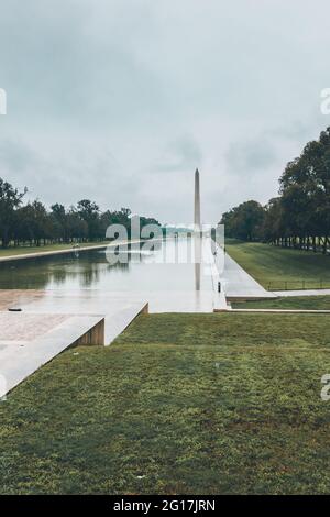 The Washington Monument in Washinton D.C. at the end of the Reflection Pool on a rainy day with the Lincoln Memorial in the background Stock Photo