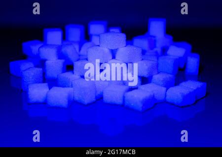 Sugar cubes in different arrangements and colored light. Arrows, Cubes, Pile, Square. Bavaria Germany Stock Photo