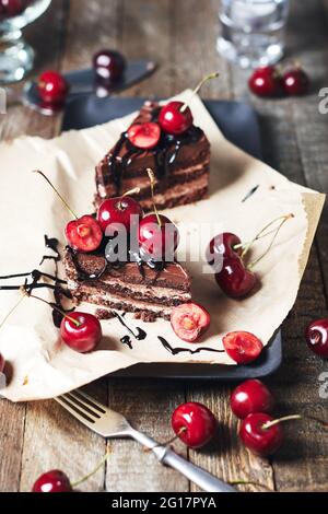 Two pieces of cake with fresh cherries on a wooden table. Stock Photo