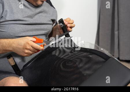 a man assembles a new chair at home. Stock Photo