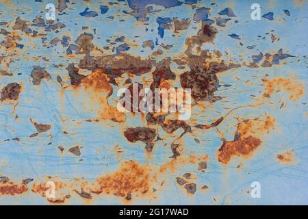 Rust.Old blue painted wall with rust spots.Textured rusty metal background. Rust stains through the cracked blue paint Stock Photo