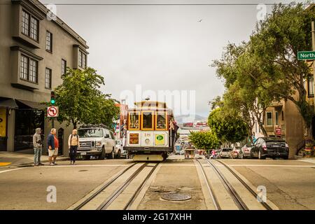 Powell and Market cable car on Hyde Street on the way to Pier 39 and people with their phones taking photos on the cable car Stock Photo