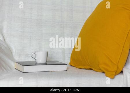 A soft yellow or mustard-colored pillow on a cozy sofa Stock Photo