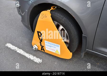 DVLA wheelclamp on front wheel of parked car, UK