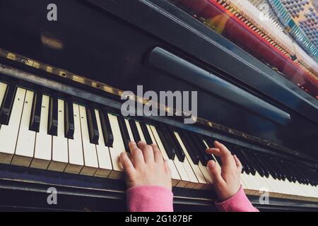 Children's hands on the keys of the old piano. Stock Photo