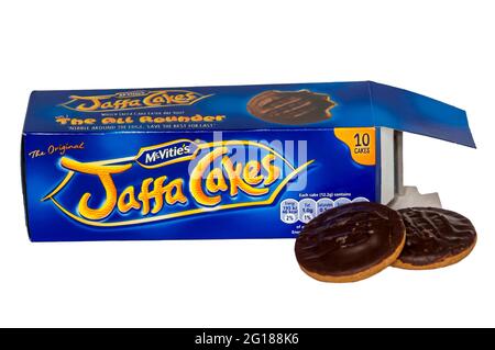 An opened box of McVities Jaffa Cakes with two Jaffa Cakes next to the box. Stock Photo