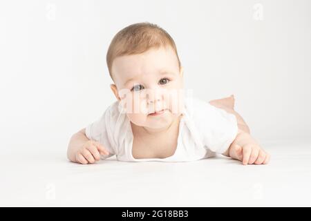 portrait of a baby, face without emotions, look at the camera on a white background Stock Photo