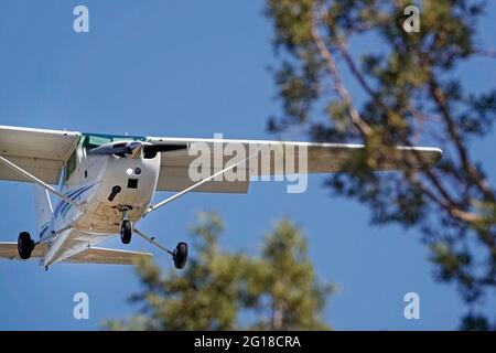A small plane used to train pilots at a small airport in Bend, Oregon, flies too low on a landing approach. Stock Photo