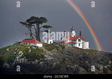 A view of a rainbow over Battery Point Lighthouse in Crescent City, California, on the Pacific Coast. The lighthouse is supposedly haunted. Stock Photo