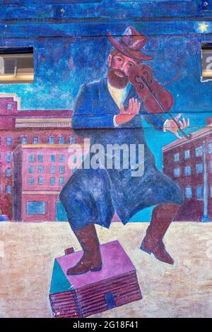 Venice Beach, CA, USA - June 20, 2013: Along boardwalk, colorful graffiti wall painting of man, Jewish fiddler dancing against blue background with ma Stock Photo